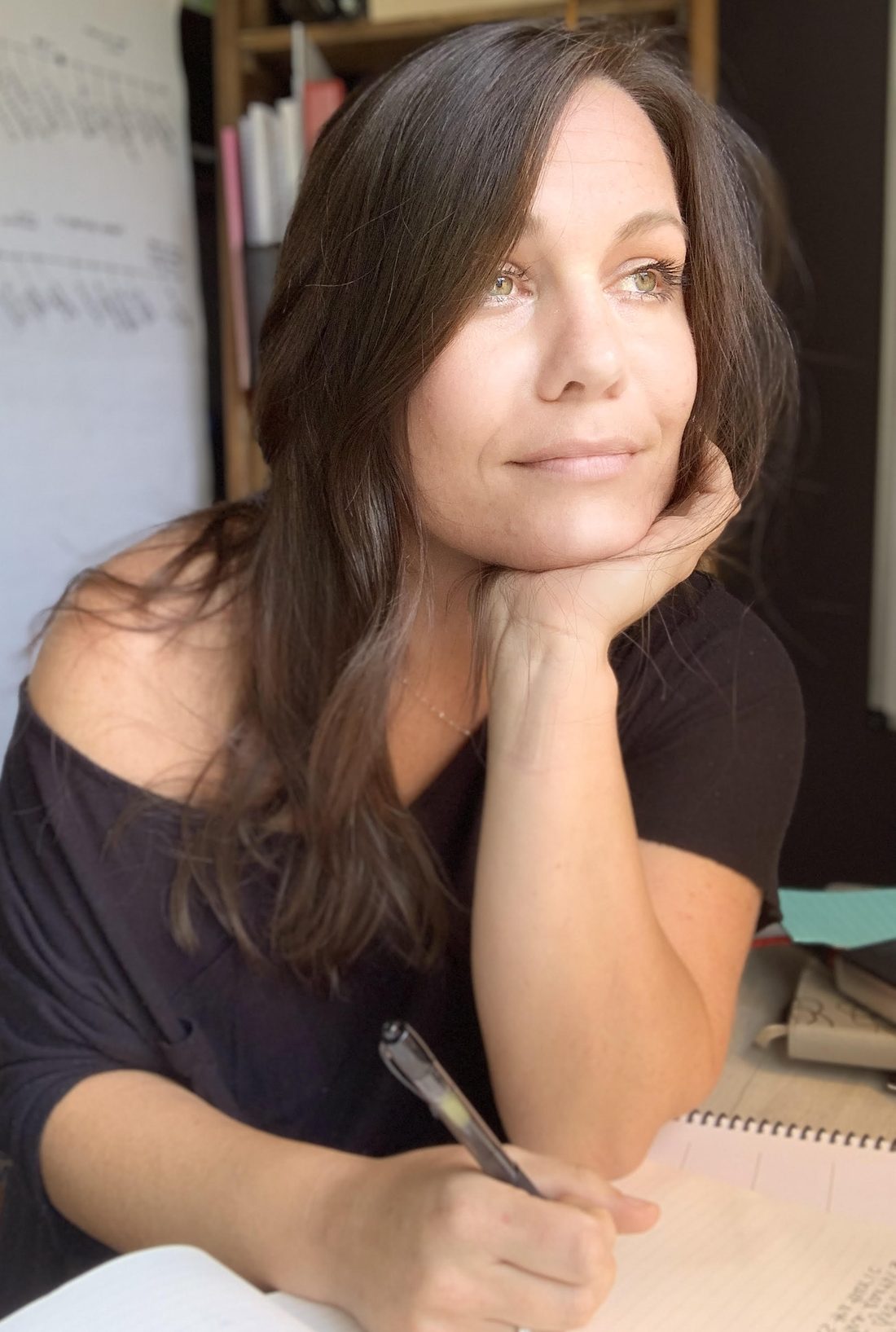 Portrait of Caitlin Surface at her desk with notebooks and charts
